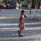 Una bimba ci viene incontro equilibrandosi su scarpe rosse da donna
